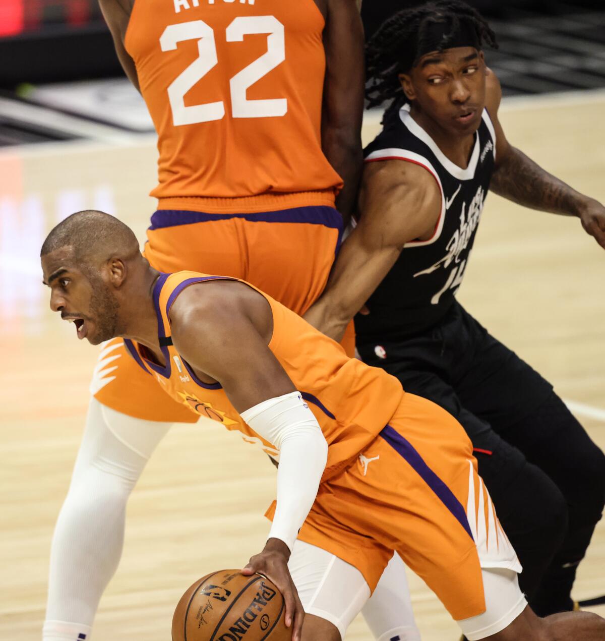The Suns' Chris Paul drives past the Clippers' Terance Mann after getting a screen from Deandre Ayton in Game 3.