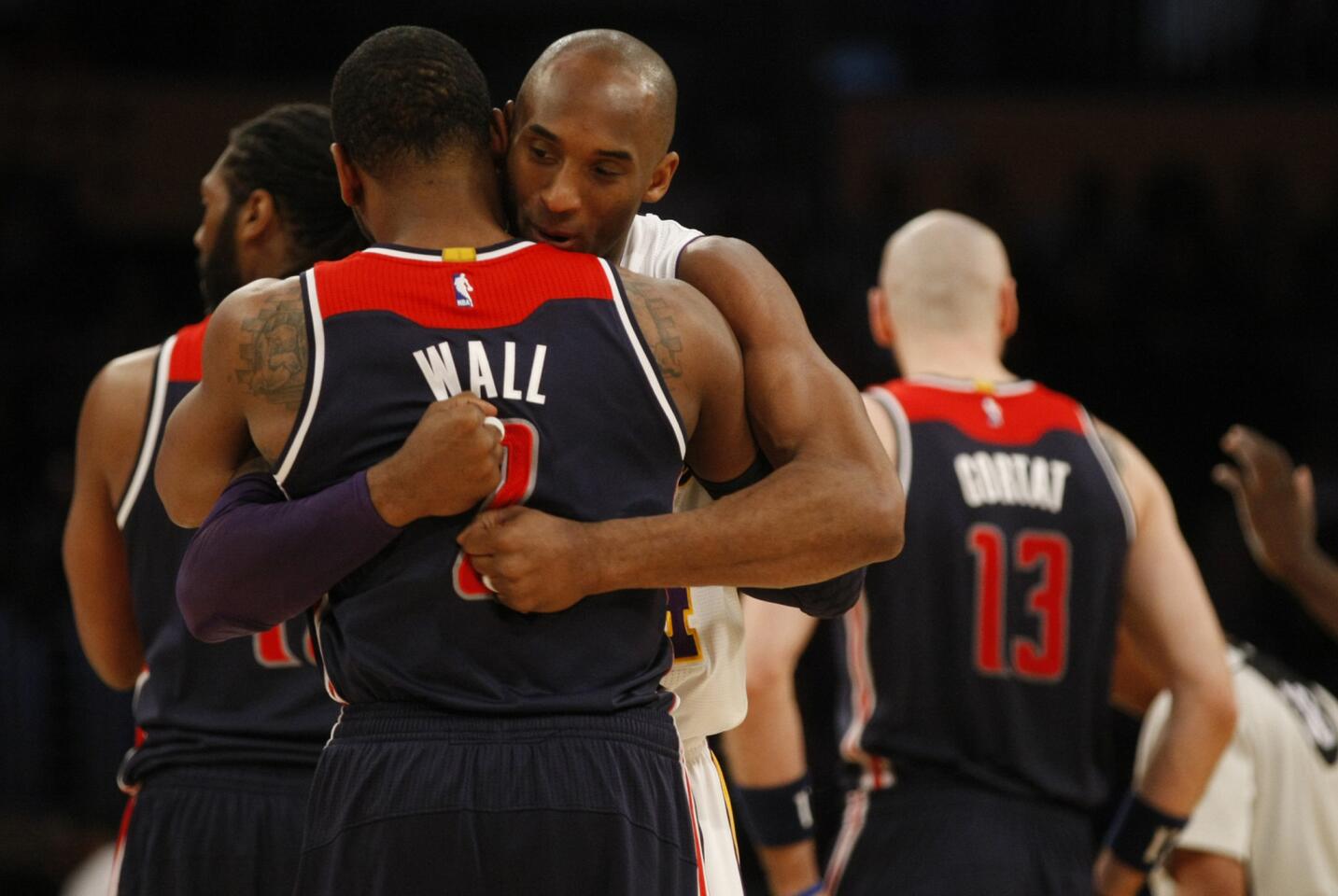 Lakers forward Kobe Bryant gives Wizards guard John Wall a hug at the start of their game on March 27.