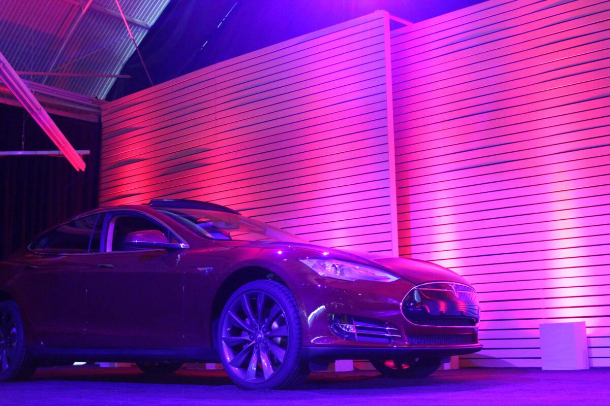 A Tesla Model S waited off to the side of the huge stage inside the carmaker's Hawthorne studios Thursday night, waiting for its debut as demo car for the new battery swap system.