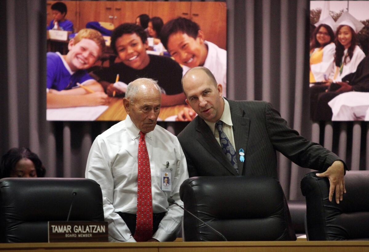 Los Angeles schools Supt. Ramon Cortines, left, talks with board member Steven Zimmer just before the board ratified Cortines' contract.