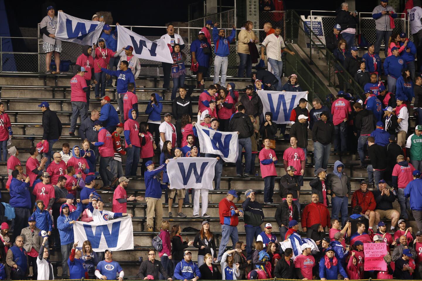 Cubs fans in the bleachers celebrate the Cubs' 4-3 victory.