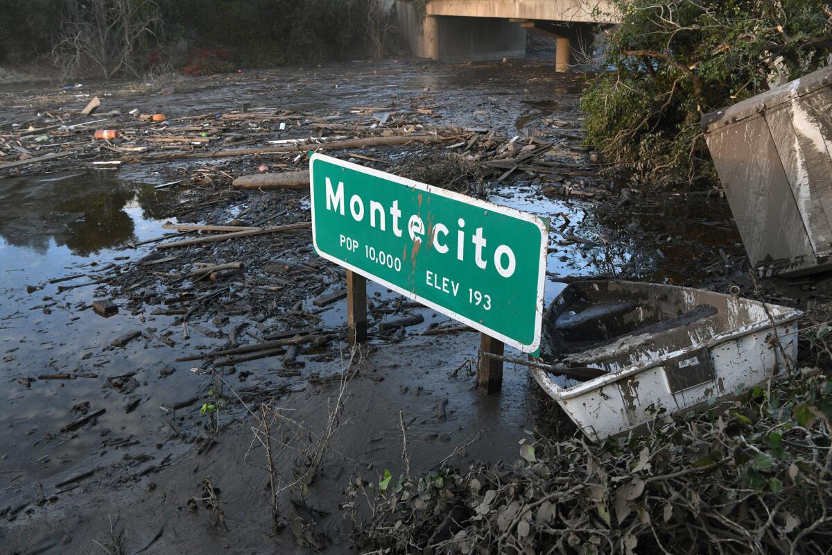 Un letrero de la autopista Montecito se asienta en el barro en la carretera U.S.-101.