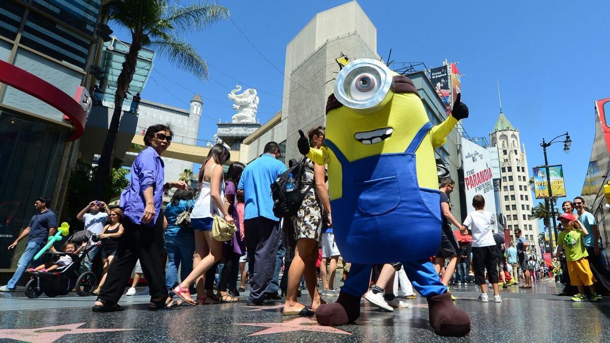 A man dressed in a Minion costume from the 'Despicable Me' movies strikes a pose along Hollywood Boulevard in L.A. The county set a record for hosting tourists for the seventh year in a row.