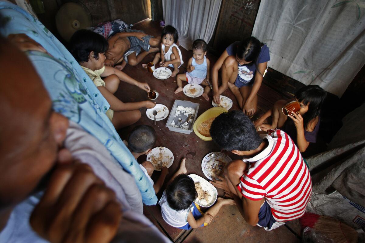 The Naz family gathers for a meal, in the same room where everyone sleeps. When food is especially scarce, only the children eat. With 12 million people, greater Manila is one of the most densely populated places on Earth. About a third of its residents live in poverty.