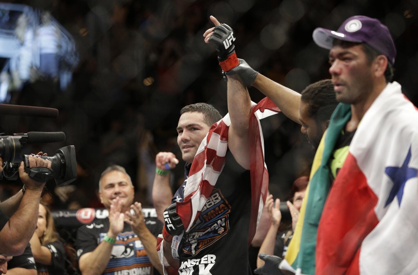 Chris Weidman raises his hand in victory after defending his UFC middleweight belt against Lyoto Machida.