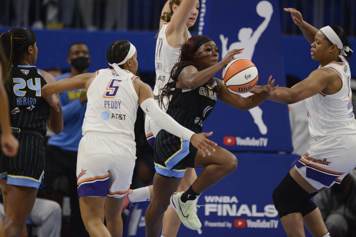 Chicago Sky's Dana Evans (11) competes against Phoenix Mercury's Kia Vaughn, right,and Alanna Smith, center rear, for a loose ball during the second half of Game 3 of basketball's WNBA Finals on Friday, Oct. 15, 2021, in Chicago. Chicago won 86-50. (AP Photo/Paul Beaty)
