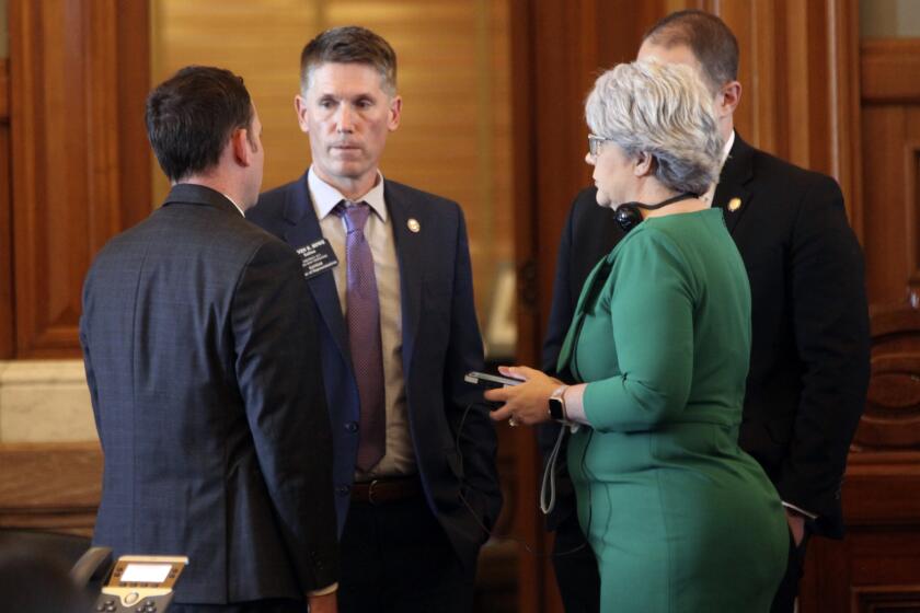 Kansas state Rep. Steve Howe, center, R-Salina, confers with House Speaker Pro Tem Blake Carpenter, left, R-Derby, and Susan Estes, right, R-Wichita, during a debate on a bill that would limit the use of diversity, equity and improvement in admitting students and hiring or promoting on state university campuses, Wednesday, March 20, 2024, at the Statehouse in Topeka, Kan. Republican lawmakers in more than 20 states are pursuing measures to restrict DEI initiatives. (AP Photo/John Hanna)