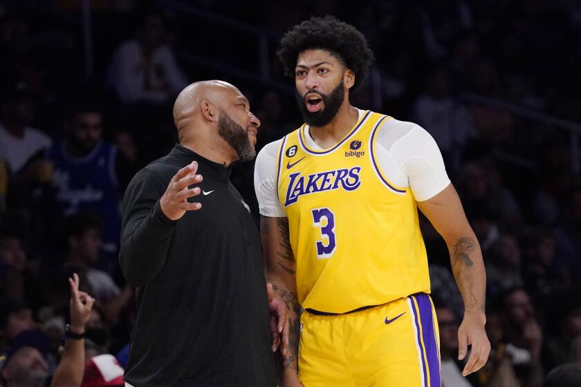 Los Angeles Lakers head coach Darvin Ham, left, talks with forward Anthony Davis during the first half of a preseason NBA basketball game against the Sacramento Kings Monday, Oct. 3, 2022, in Los Angeles. (AP Photo/Mark J. Terrill)