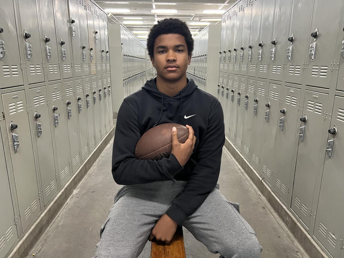 Birmingham High quarterback Kingston Tisdell poses for a photo in the locker room.
