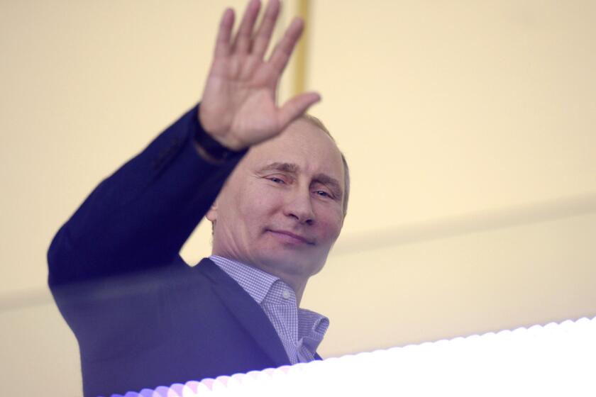 Russian President Vladimir Putin waves during the Men's Ice Hockey Group A match of the USA vs. Russia at the Bolshoy Ice Dome during the Sochi Winter Olympics on February 15, 2014, in Sochi.