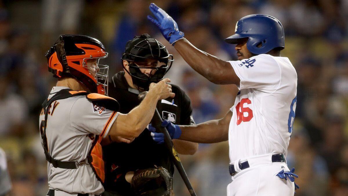 Dodgers' hitter Yasiel Puig shoves San Francisco Giants catcher Nick Hundley at the plate in the bottom of the seventh inning against at Dodger Stadium on Tuesday.