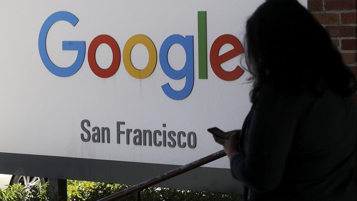 A woman walks past a Google sign in San Francisco on May 1.