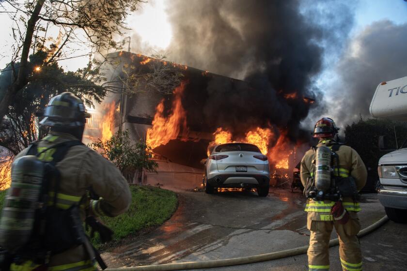 Firefighters battle a fire at a fully engulfed home in Vista on April 16, 2024.