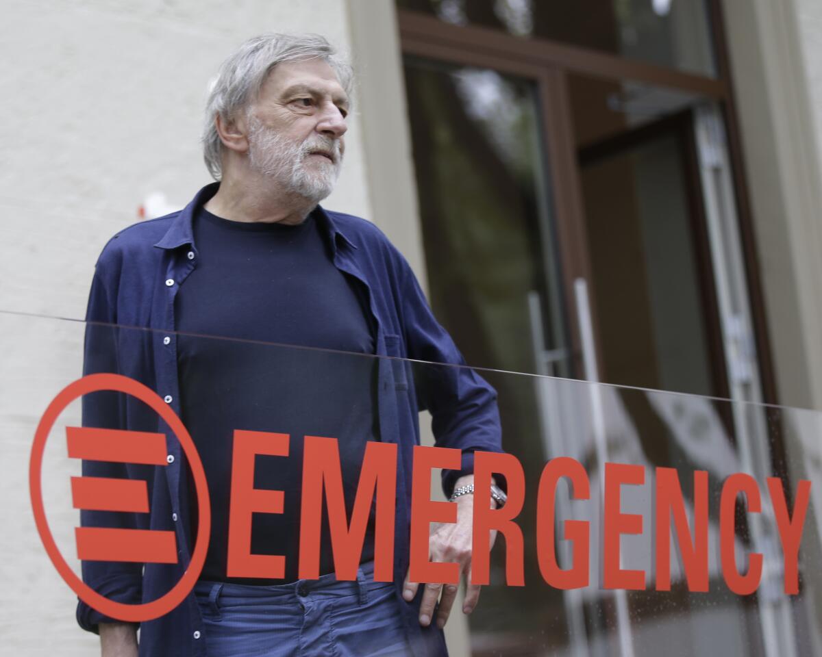 FILE - In this file photo dated Thursday, Sept. 14, 2017, Italian aid group 'Emergency' founder Gino Strada poses during the unveiling of the new Emergency headquarter in Milan, Italy. 73-year old Gino Strada, the Italian surgeon who co-founded the humanitarian organization Emergency with his wife, to provide medical care for civilian victims of war and poverty, died on Thursday Aug. 13, 2021, according to a family statement.(AP Photo/Luca Bruno, FILE)