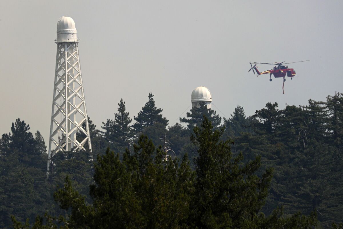 A helicopter fights the Bobcat fire burning dangerously close to Mt. Wilson Observatory.