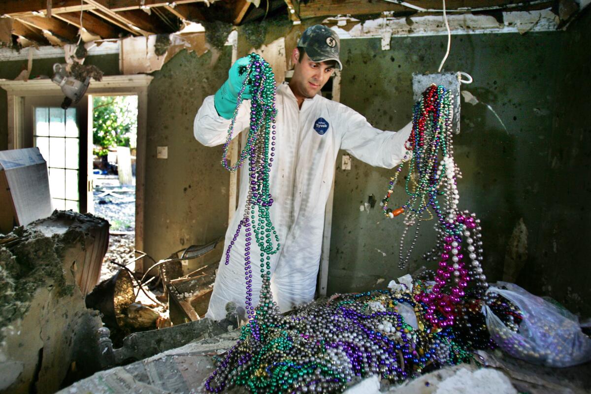 Jason Gisclair sorts through a pile of Mardi Gras beads while salvaging items from his parents' house Sunday, Oct. 30, 2005, in Chalmette, La. Flood waters from Hurricane Katrina destroyed the community.