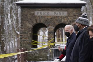 President Joe Biden visits the site where the Fern Hollow Bridge collapsed Friday, Jan. 28, 2022, in Pittsburgh's East End. Pittsburgh Mayor Ed Gainey, second from right, and Commerce Secretary Gina Raimondo, right, look on. (AP Photo/Andrew Harnik)