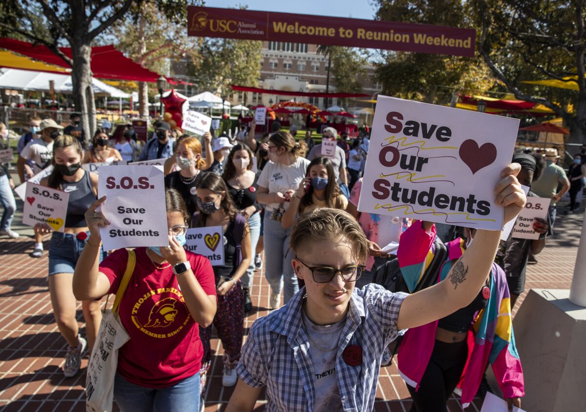 USC student protests on campus holding signs. 