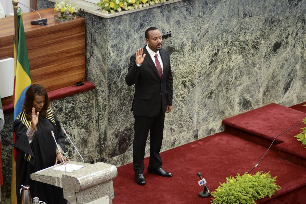Abiy Ahmed holds up his right hand at his swearing-in ceremony