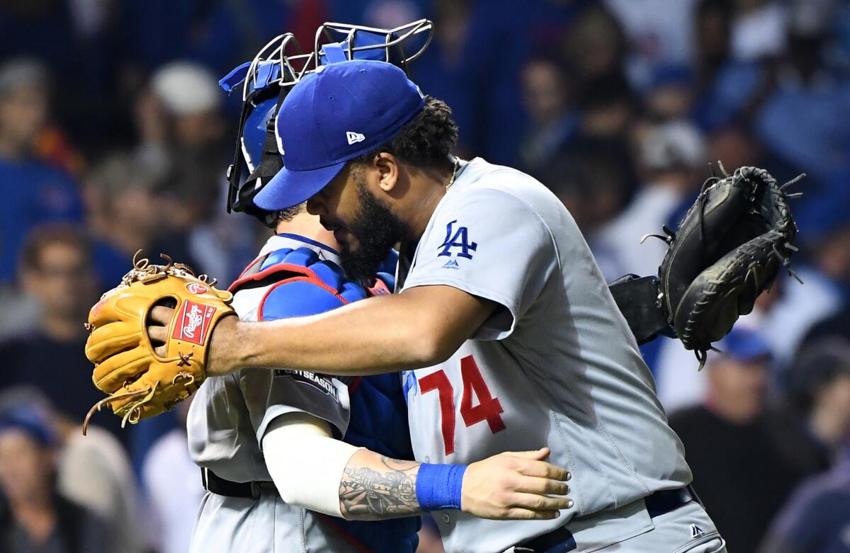 Dodgers reliever Kenley Jensen, right, embraces catcher Yasmani Grandal after recording a six-out save against the Cubs in Game 2.