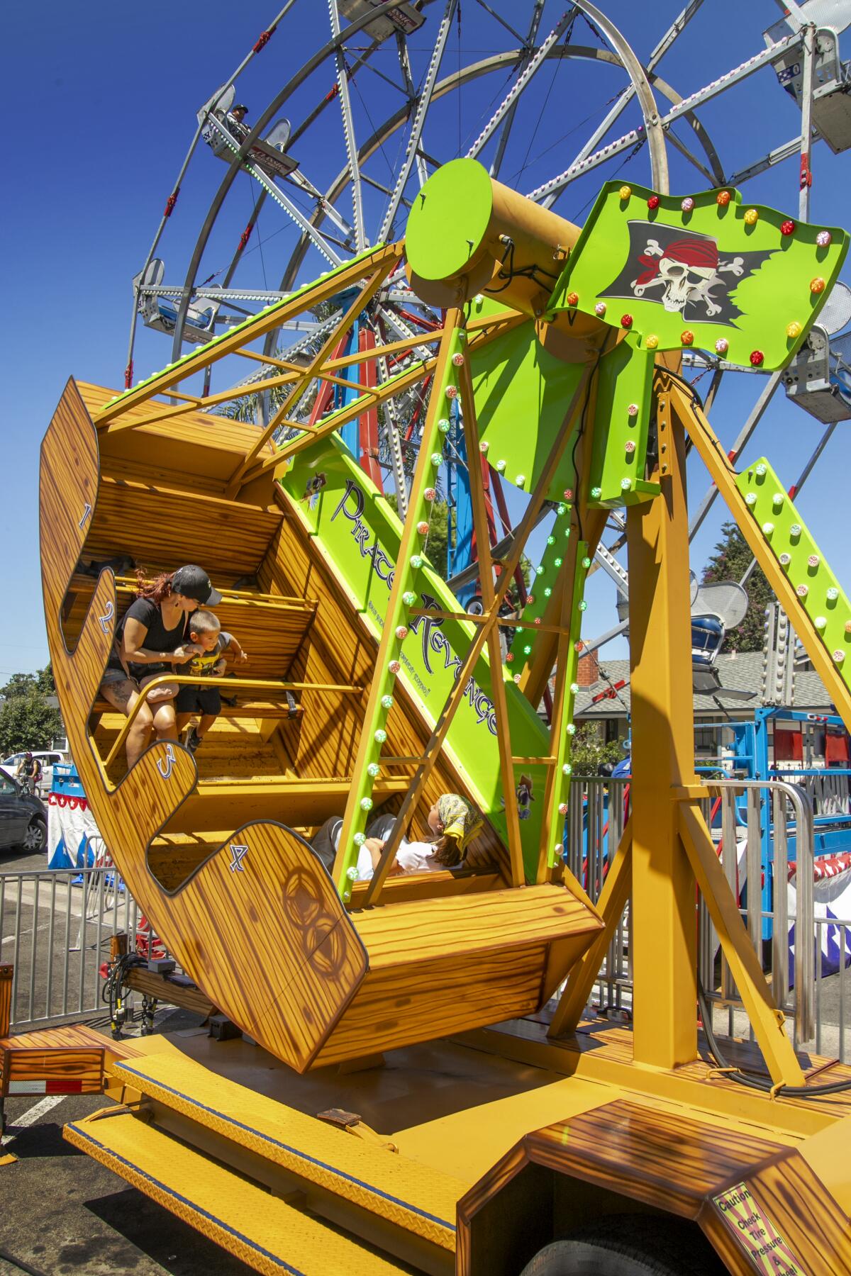 Agueda Bradley and son Milo, 2, ride the Pirates Revenge at the festival.