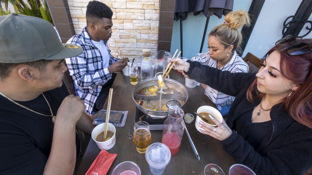People eat at a restaurant outdoors. 