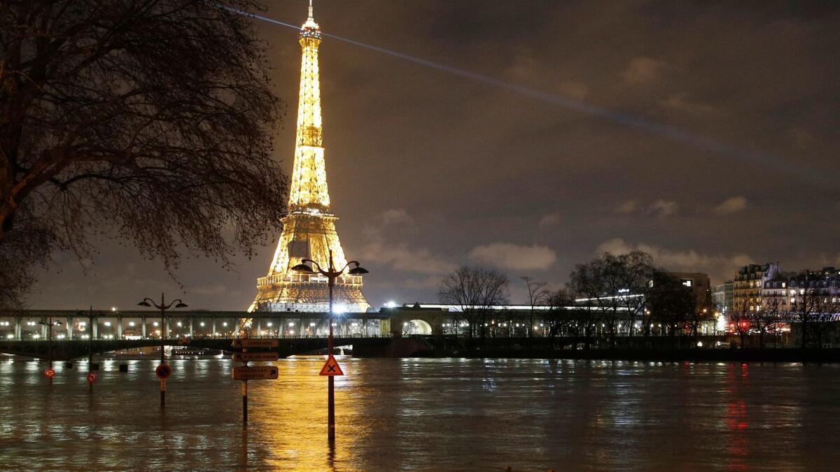 Streetlamps and signboards serve as markers for floodwater levels next to the River Seine in Paris on Jan. 27, 2018.