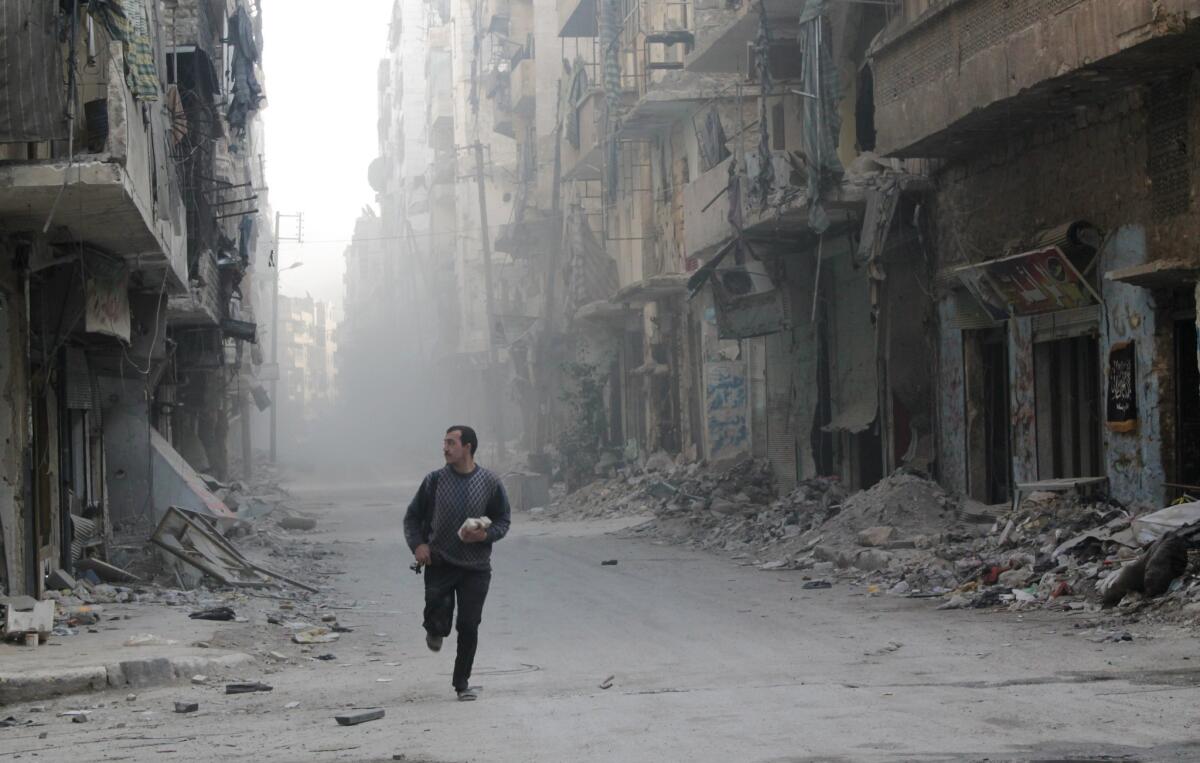 A rebel fighter from the Free Syrian Army runs in a street of Aleppo's Salah al-Din neighbourhood during fighting against Syrian government forces on Monday.