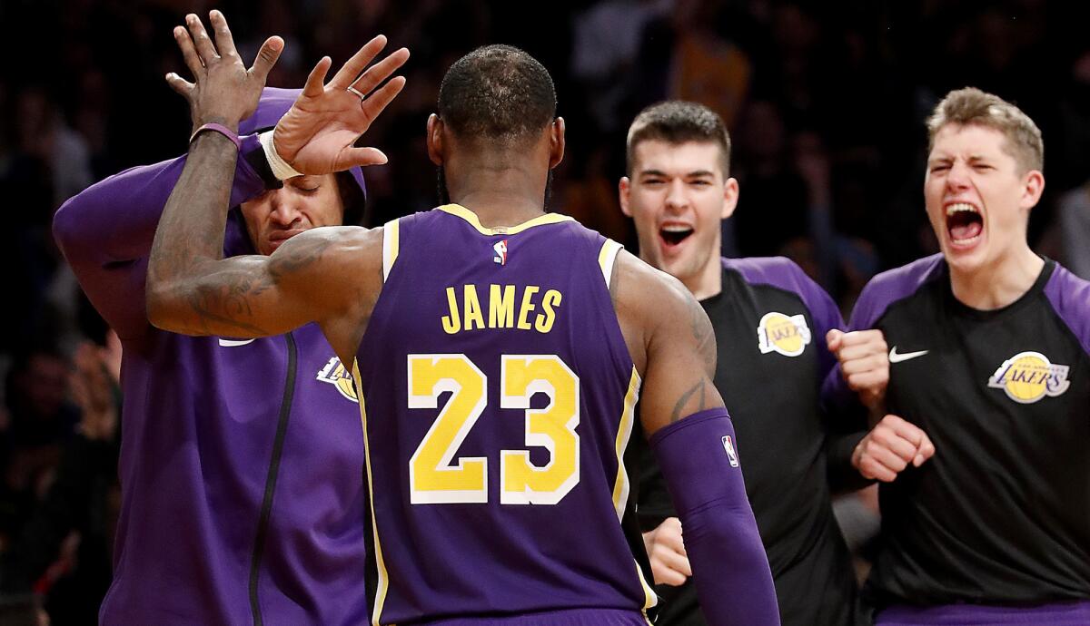 Lakers forward LeBron James is congratulated by teammates after scoring against the Spurs during the fourth quarter Wednesday night at Staples Center.