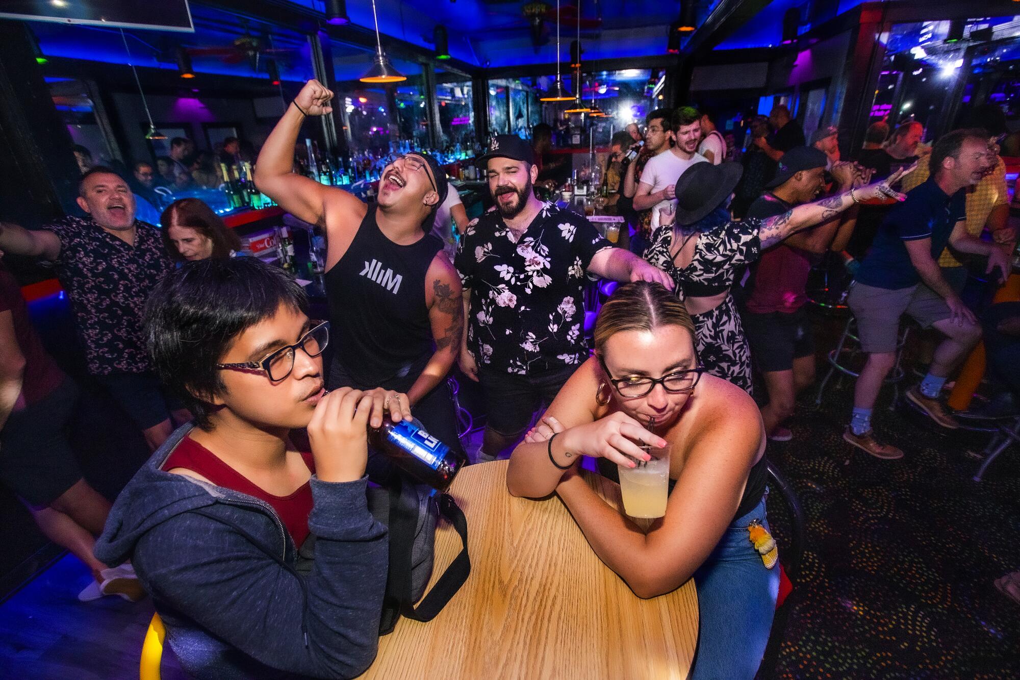 A crowd drinks and celebrates being back inside a bar.