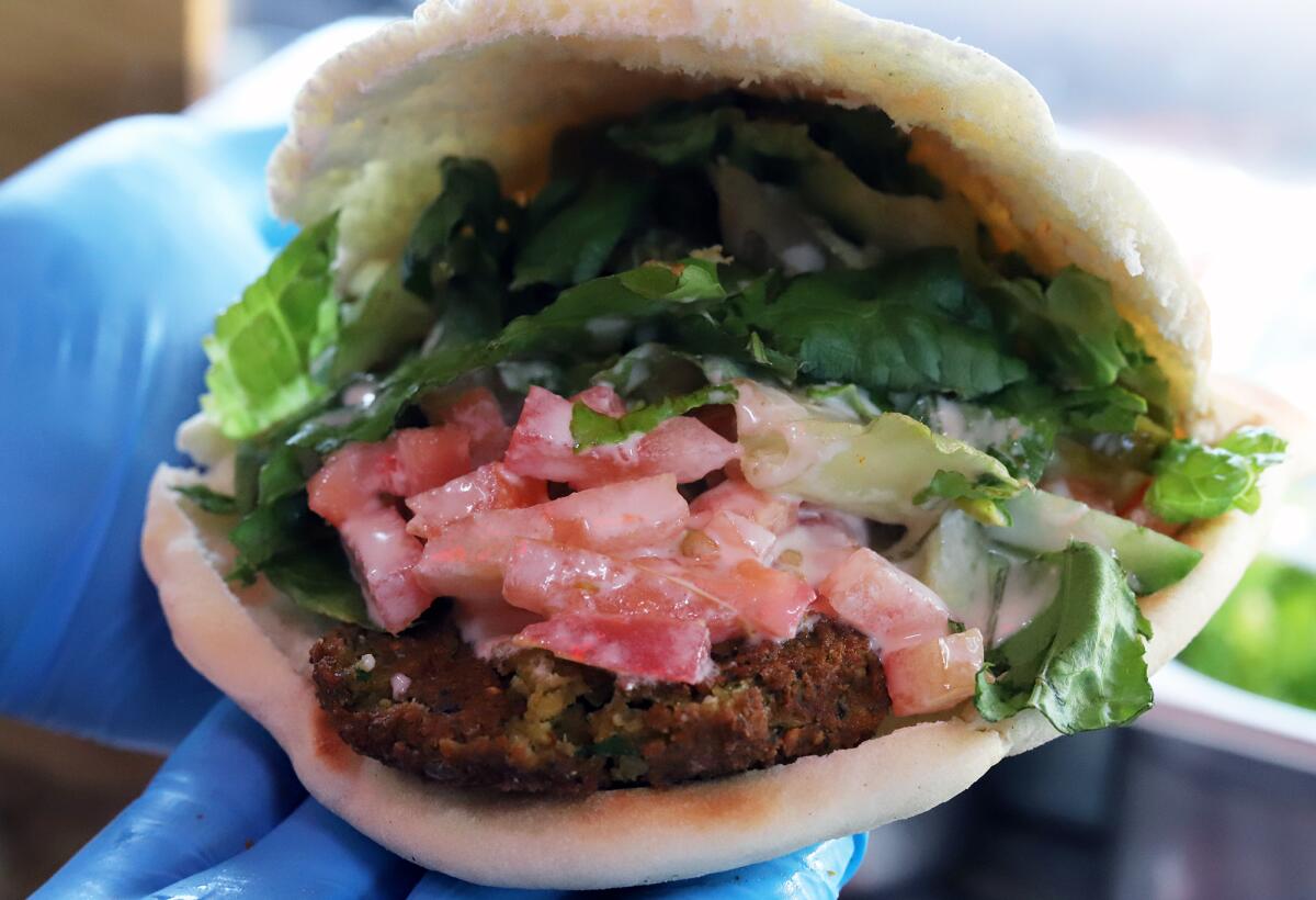 Falafel sandwiches filled with lettuce, tomato, tahini sauce are a draw at the Balad Falafel.