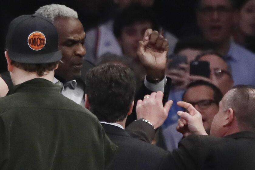 Former New York Knicks player Charles Oakley exchanges words with a security guard during the first quarter of the Knicks-Clippers game Wednesday.