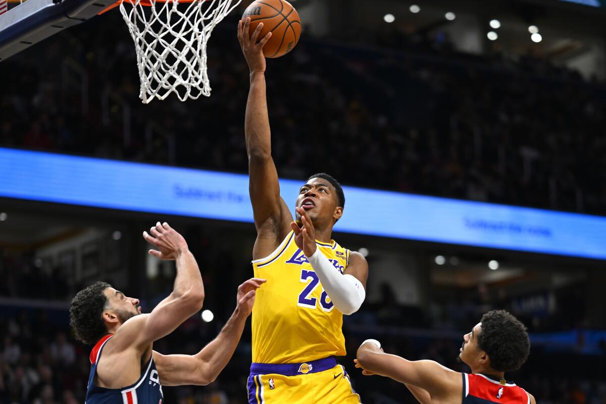 Lakers forward Rui Hachimura scores against Wizards forward Anthony Gill, left, and guard Jordan Poole on Wednesday night.