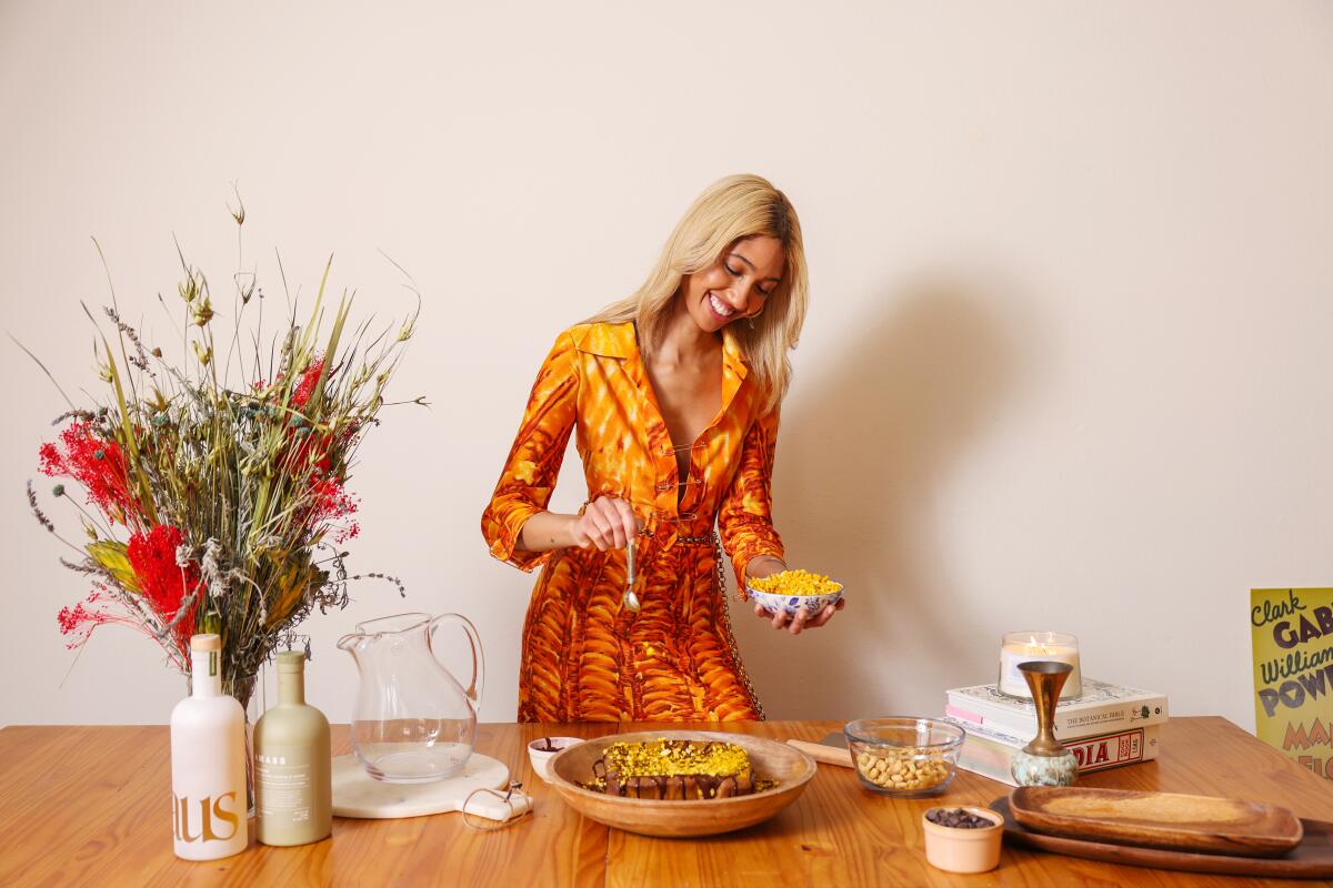 Morgan Lynzi sprinkles a topping on her 24 Carrot Gold Cake