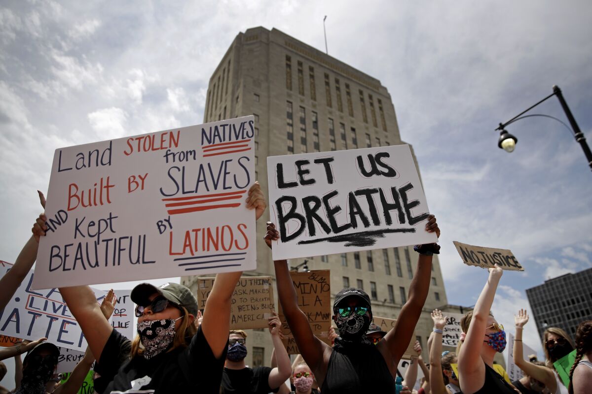 People hold signs during a June 5 rally in downtown Kansas City, Mo., to protest the death of George Floyd