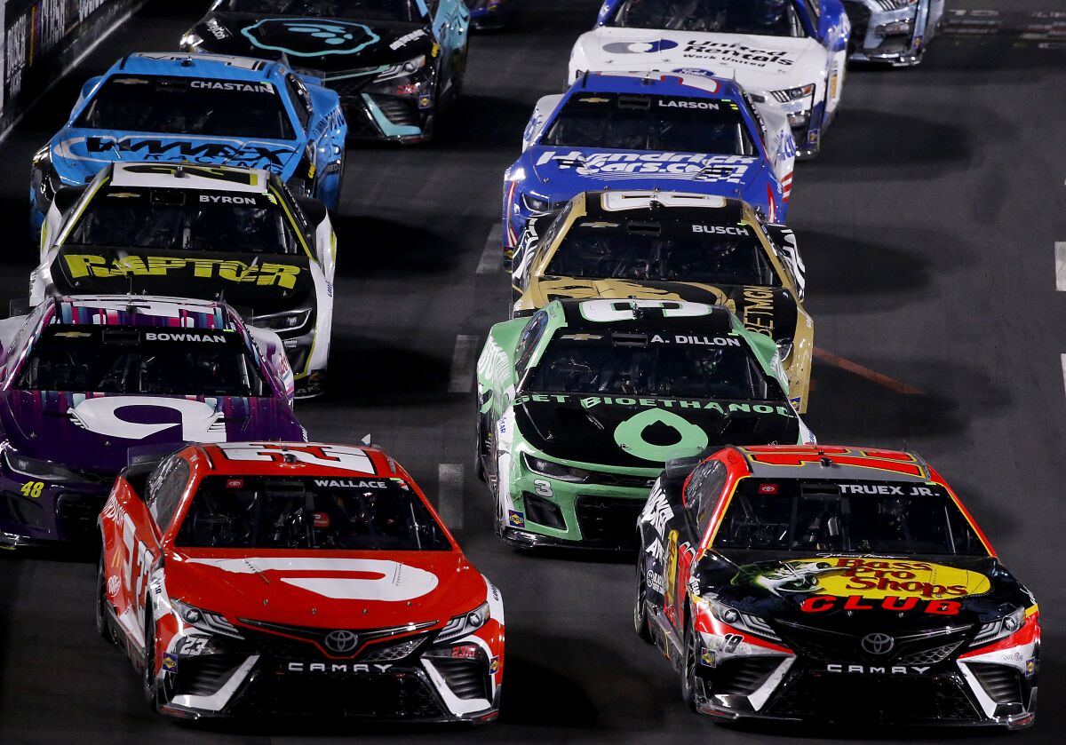 Martin Truex Jr., right, leads the pack during a late-race restart during the NASCAR Busch Light Clash at the Coliseum.