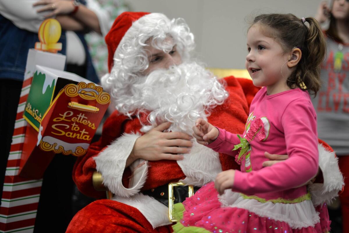 A young girl visits with Santa Claus during the 7th annual Brunch with Deaf Santa at Mountwest Community and Technical College in Huntington, W.Va.