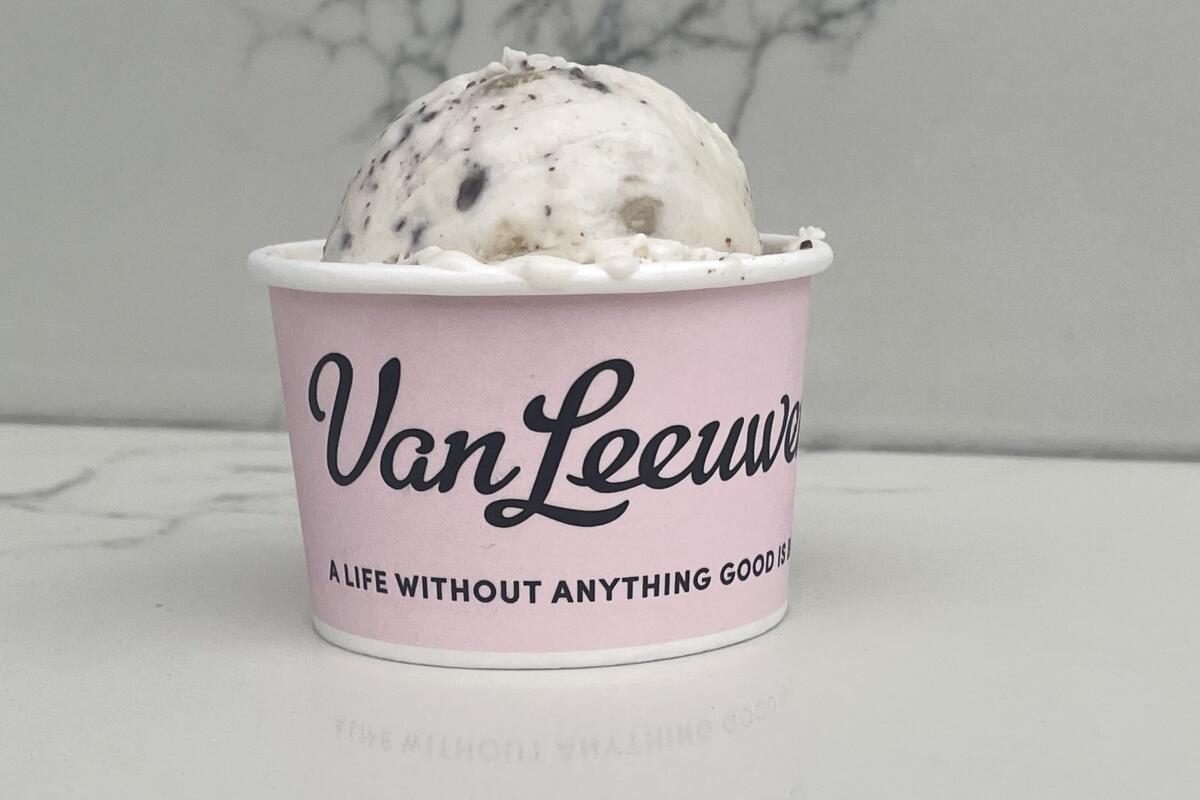 A scoop of ice cream in a paper cup that says Van Leeuwen