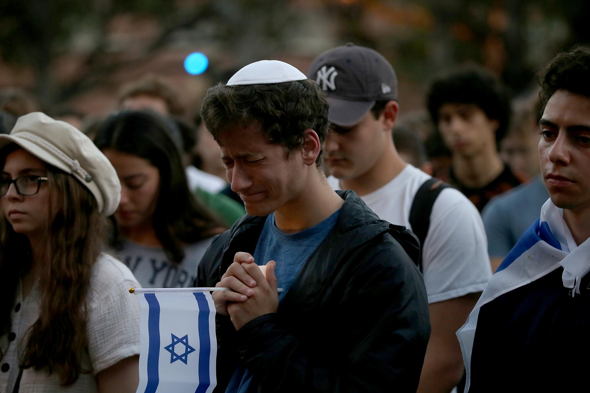 A student in a yarmulke holds an Israeli flag.