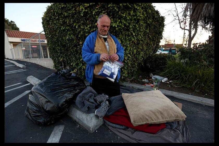 John Wagner, 54, who has been homeless for 14 years, holds a City Net care package given to him in the 600 block of West 19th Street in Costa Mesa during Wednesday's Point in Time count of Orange County's homeless.