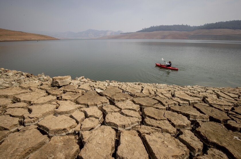 FILE - A kayaker fishes in Lake Oroville as water levels remain low due to continuing drought conditions in Oroville, Calif., on Aug. 22, 2021. California water agencies that serve 27 million residents and 750,000 acres of farmland won't get any of the water supplies they're requesting from the state heading into 2022, state water officials announced Wednesday, Dec. 1, 2021. (AP Photo/Ethan Swope, File)