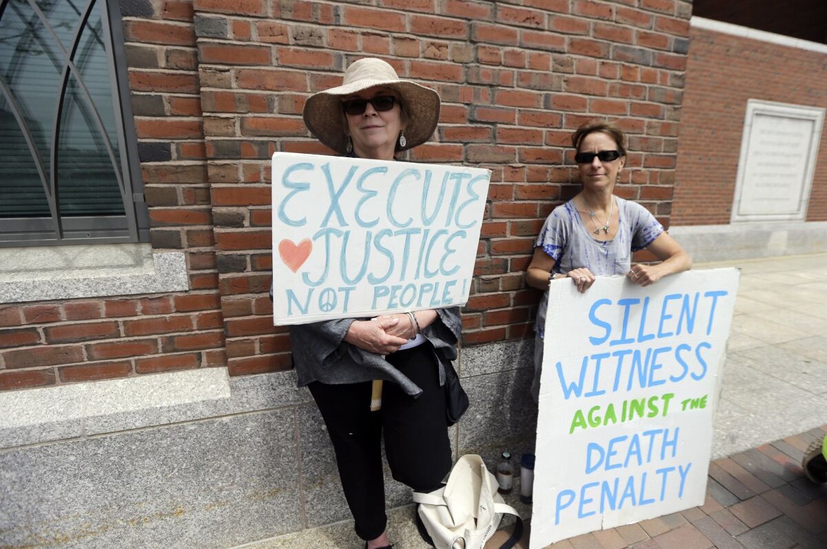 Demonstrators hold signs against the death penalty outside federal court in Boston during the penalty phase in Boston Marathon bomber Dzhokhar Tsarnaev's trial on May 11, 2015.