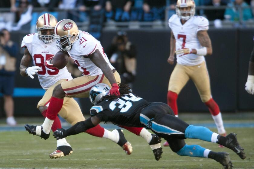 San Francisco 49ers' Frank Gore, second from left, breaks a tackle by Carolina Panthers' Robert Lester during a game in January. Former California Assemblyman Jeff Miller (R-Corona) has agreed to pay a $1,000 fine for improperly accepting two tickets to a San Francisco 49ers football game.