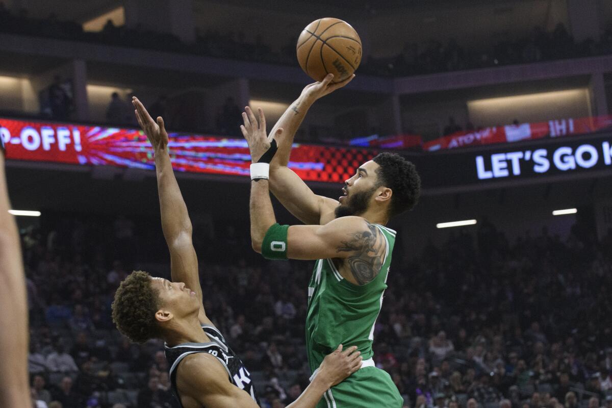 Jayson Tatum, alero de los Celtics de Boston, dispara sobre Kessler Edwards,