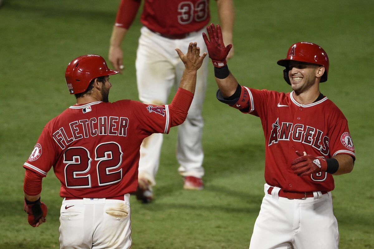 The Angels' Tommy La Stella celebrates with David Fletcher after hitting a walk-off, two-run home run Aug. 17, 2020. 