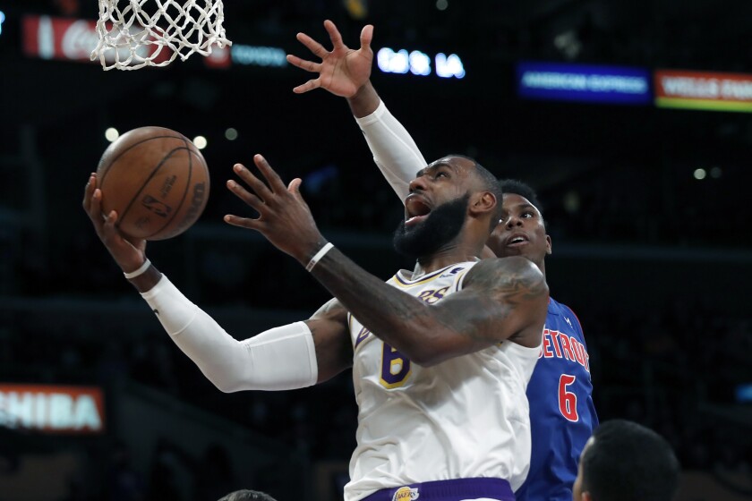 LeBron James, izquierda, de los Lakers de Los Ángeles, intenta encestar en contra del base Hamidou Diallo, de los Pistons de Detroit, en duelo de NBA del domingo 28 de noviembre de 2021, en Los Ángeles. (AP Foto/Alex Gallardo)