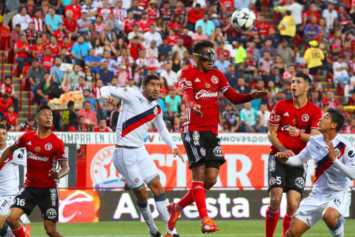 Juan Valenzuela (d) de Tijuana disputa el balón contra Jair Pereira (i) de Chivas, durante un partido de la jornada 3 del Torneo Apertura del fútbol mexicano en el estadio Caliente de Tijuana (México).
