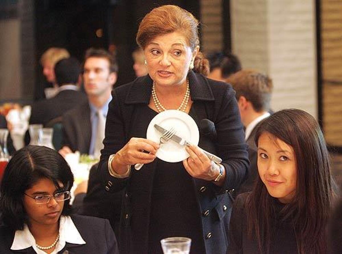 "We have earned the term 'Ugly Americans,' " says etiquette expert Ann Marie Sabath . Above, she acquaints UC Irvine business students with the proper use of dining implements.