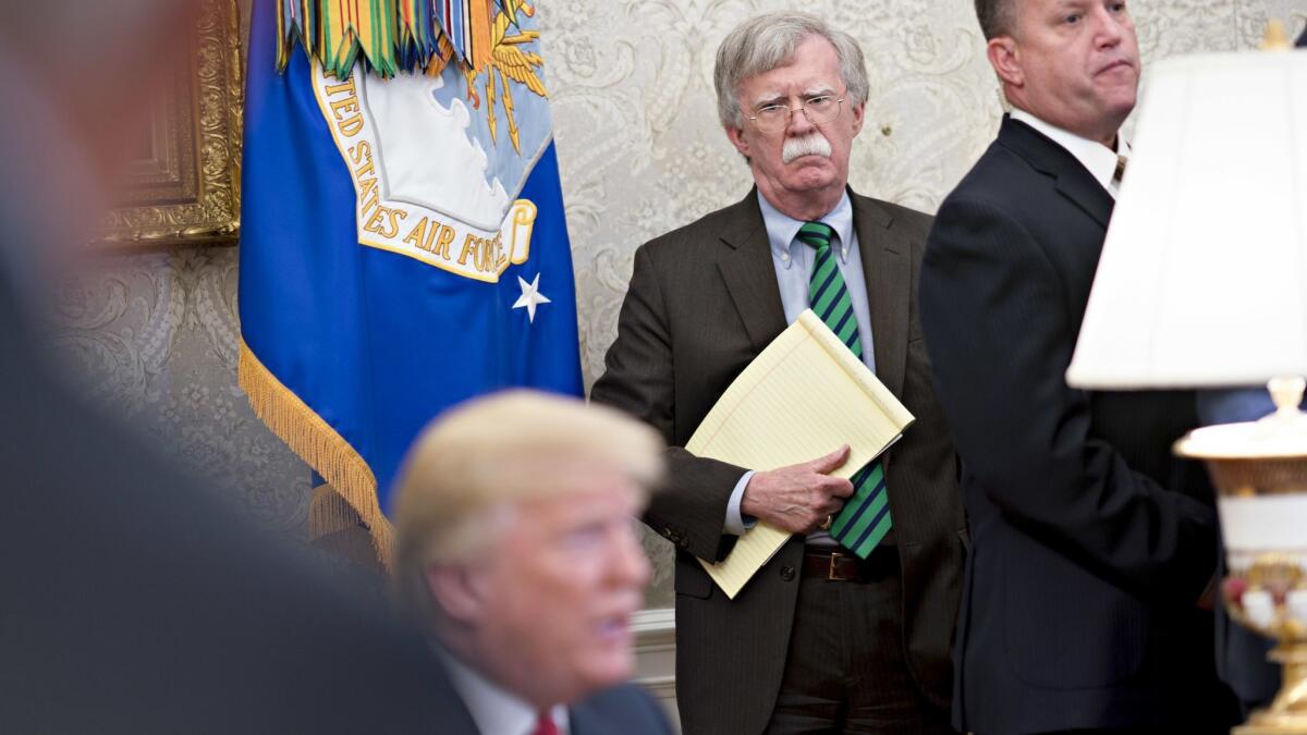 John Bolton, national security advisor, center, listens as President Trump comments on North Korea and China trade during a photo session Thursday in the Oval Office.