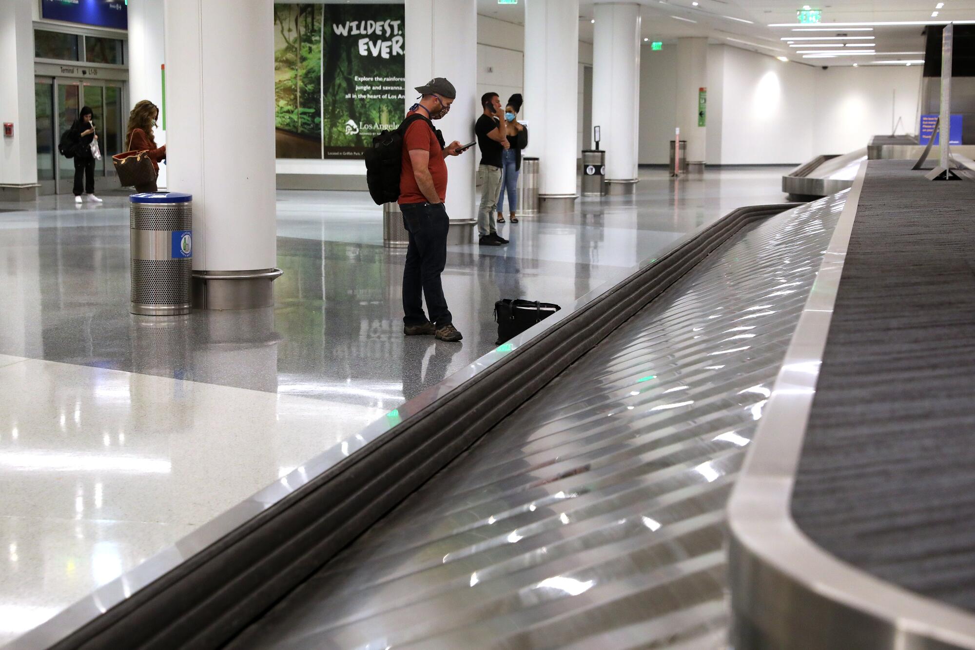 A few passengers wait at a Southwest Airlines baggage pickup carousel inside Terminal One at LAX.